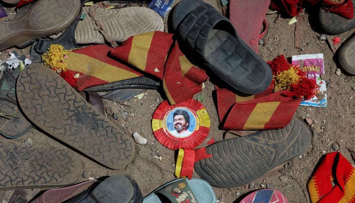 A badge with picture of Vijay, actor and politician, lies amid footwears and other belongings left by attendees at the site of a stampede incident during an election campaign rally held by Tamilaga Vettri Kazhagam party, in Karur district of Tamil Nadu, India, September 28, 2025.— Reuters