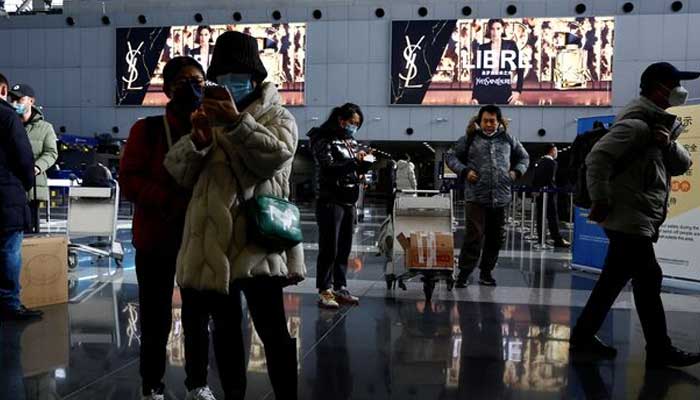 Travellers stand by their luggage at Beijing Capital International Airport in Beijing, China. — Reuters/File