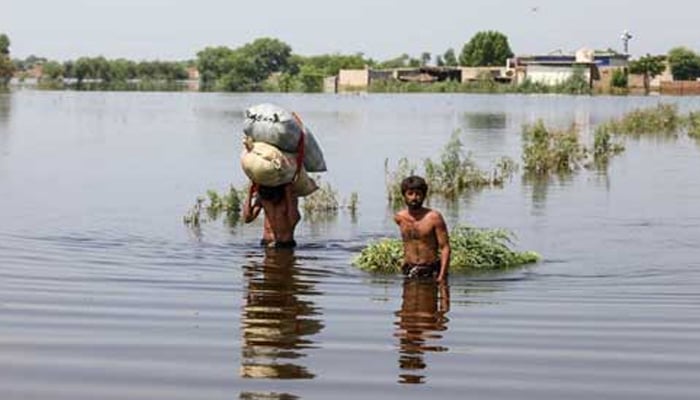 Two men can be seen in a flood-affected area. — Unicef