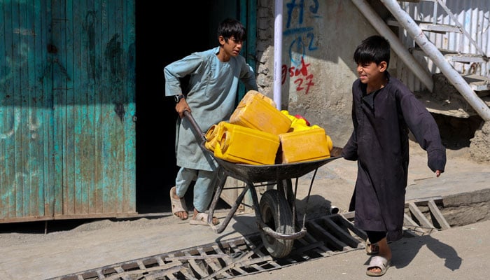 Eight-year-old Sanaullah (right) and his twin brother Noorullah (left) move a handcart with empty barrels to fetch water, amid serious water crisis in Kabul, Afghanistan, September 14, 2025. —Reuters
