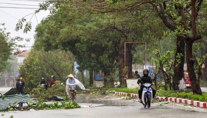 People commute on a partially flooded street after Typhoon Bualoi makes landfall in Nghe An province, Vietnam, September 29, 2025. — Reuters