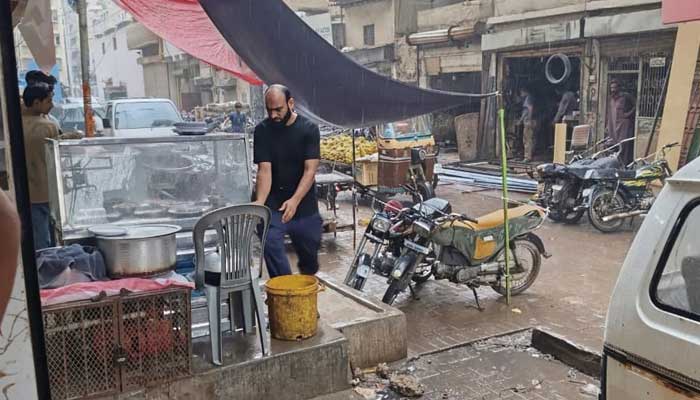 People pictured at a market in Karachi during rain on September 30, 2025. — Geo.tv