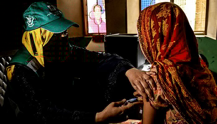 A health worker (left) administers human papillomavirus (HPV) vaccine to a girl in Karachi on September 24, 2025, during a HPV vaccination drive against cervical cancer, most frequently diagnosed in women. — AFP