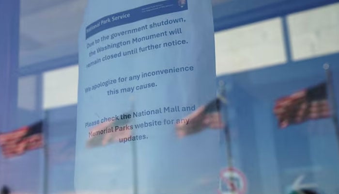 A notice informing that the Washington Monument is closed because of a partial government shutdown is attached to a glass door, as US flags are reflected on it, on the first day of a partial government shutdown, in Washington, DC, US, October 1, 2025. —Reuters