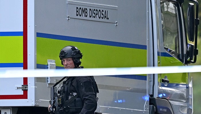 An Armed Police officer walks past a bomb disposal van outside Heaton Park Hebrew Congregation synagogue in Crumpsall, north Manchester, on October 2, 2025, following an attack at the synagogue. — AFP