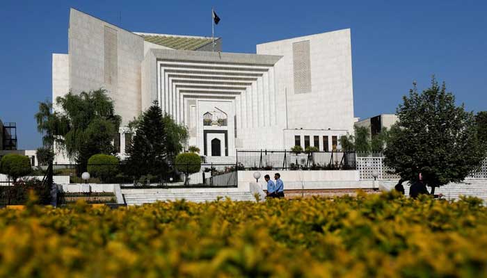 Police officers walk past the Supreme Court building, in Islamabad on April 6, 2022. — Reuters