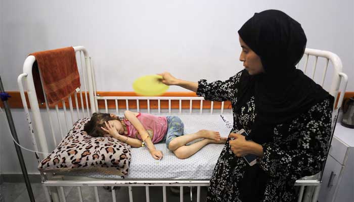 Nasma Ayad fans her daughter, Jana Ayad, who is malnourished, according to medics, as she receives treatment at a hospital in Gaza City, July 29. — Reuters