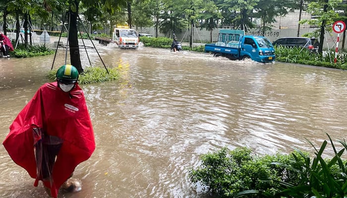 People commute on a flooded street after Typhoon Bualoi made landfall in Hanoi, Vietnam, September 30, 2025. — Reuters