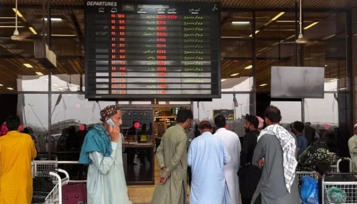 Passengers wait at Jinnah International Airport after all domestic and international flights were cancelled in Karachi on May 7, 2025. — AFP