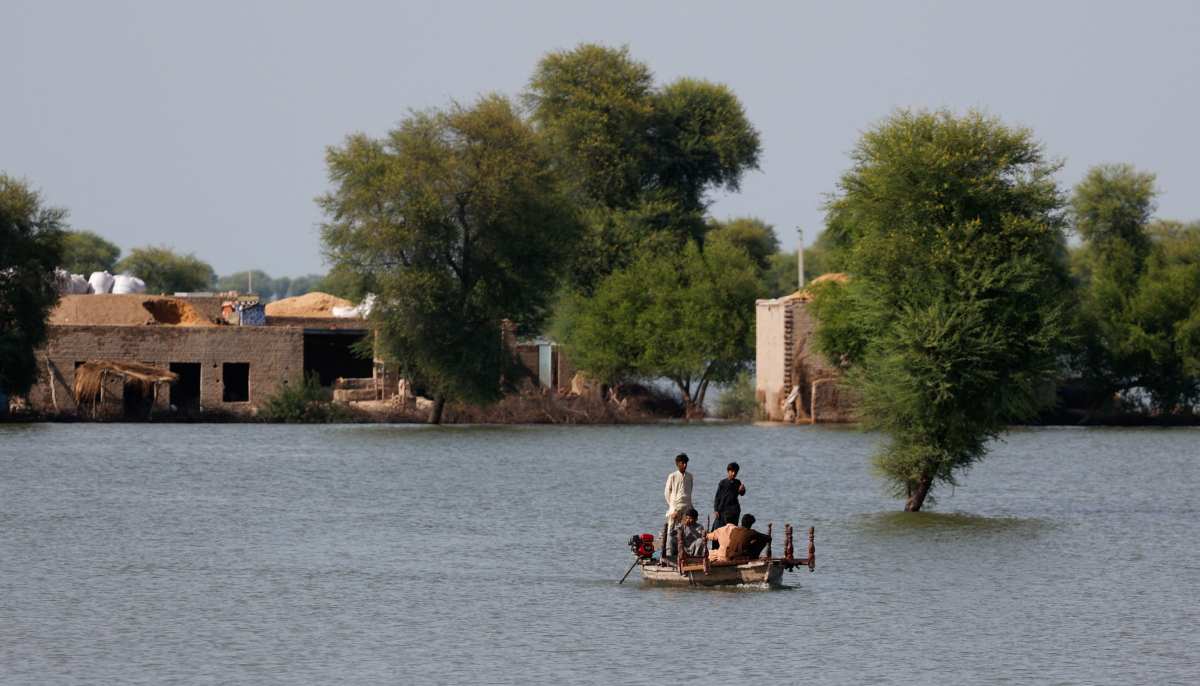 Residents travel in boat, with the partially submerged homes in the background, following monsoon rains and rising water levels of Indus River on the outskirts of Dadu in Sindh on September 15, 2025. — Reuters
