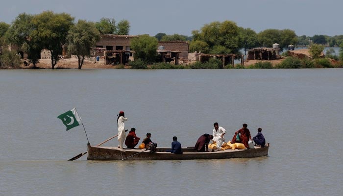 Residents travel on a boat with their supplies, through a flooded area, following monsoon rains and rising water levels of the Indus River, in Ghano Khan Jatoi village in Dadu district, Sindh province, September 12, 2025. — Reuters