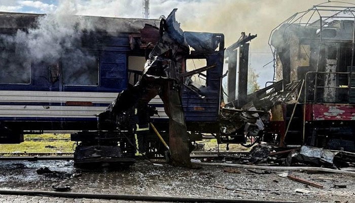 Smoke rises over a passenger train hit by todays Russian drone strike, amid Russias attack on Ukraine, at the railway station in the town of Shostka, Sumy region, Ukraine October 4, 2025.—