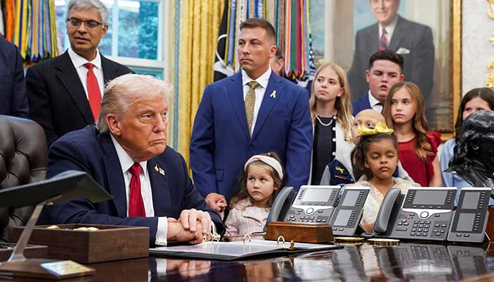 US President Donald Trump looks on next to children in the Oval Office, on the day he signs an executive order on AI and pediatric cancer research, at the White House, Washington, DC, on September 30, 2025. — Reuters