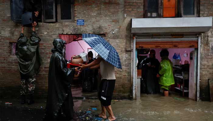 Members of Nepal Army help people retrieve their belongings to a safe area at a flooded street along the bank of overflowing Bagmati River following heavy rains, in Kathmandu, Nepal, October 4, 2025.  — Reuters