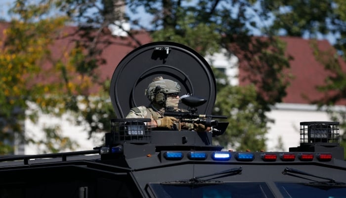 An armed law enforcement agent sits in an armoured vehicle in Chicago, Illinois, on October 4, 2025. AFP