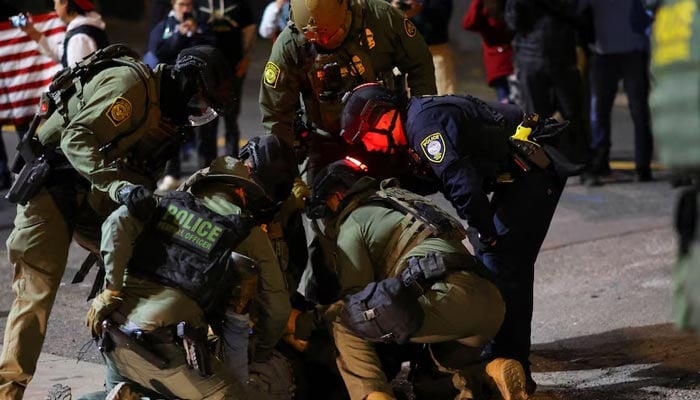 Law enforcement officers detain a protester outside the US Immigration and Customs Enforcement (ICE) headquarters in South Portland, Oregon, US, October 5, 2025. Reuters