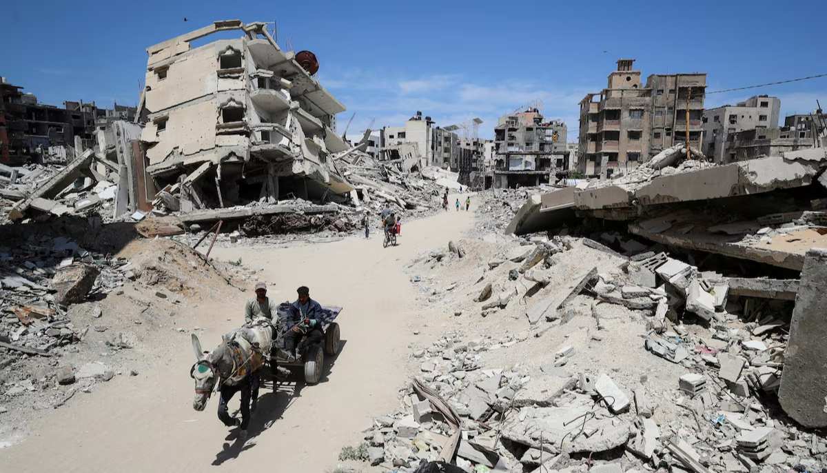 Palestinians ride a cart past the rubble of houses, in Gaza City, May 20, 2025. — Reuters