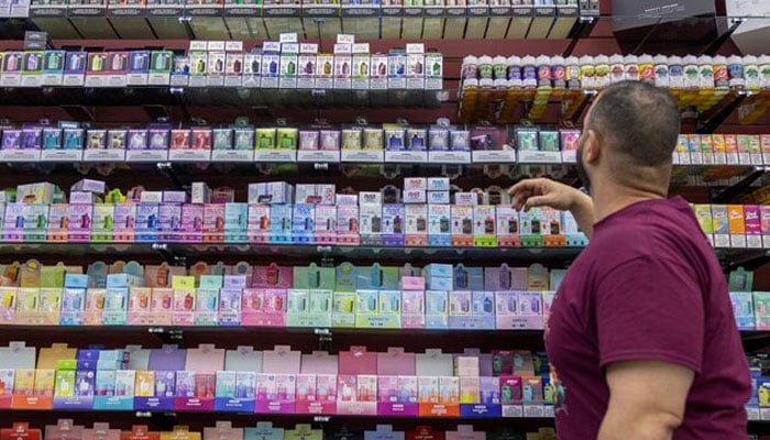 Anes Saleh, owner of Sultans Smoke, reaches for products at his store in Arvada, Colorado, US, May 21, 2024. — Reuters