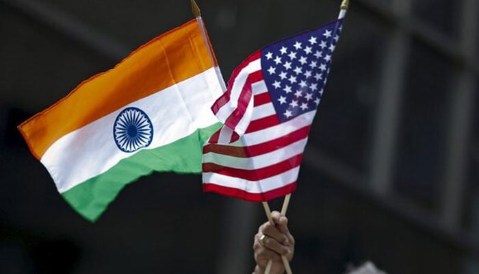 A man holds the flags of India and the U.S. while people take part in the 35th India Day Parade in New York August 16, 2015. — Reuters