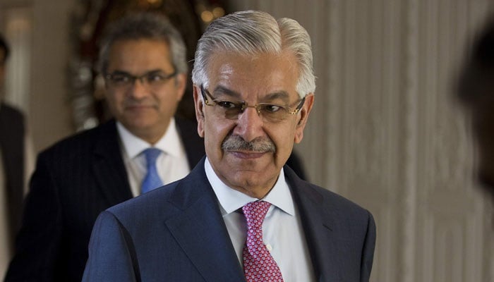 Defence Minister Khawaja Asif smiles as he looks on duing an event. — APP/File
