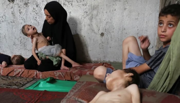 Displaced Palestinian mother Samah Matar holds her malnourished son, Ameer, who suffers from cerebral palsy, as her other son, Youssef, also malnourished and suffering from cerebral palsy, lies on a mattress at a school in Gaza City, July 24, 2025. — Reuters
