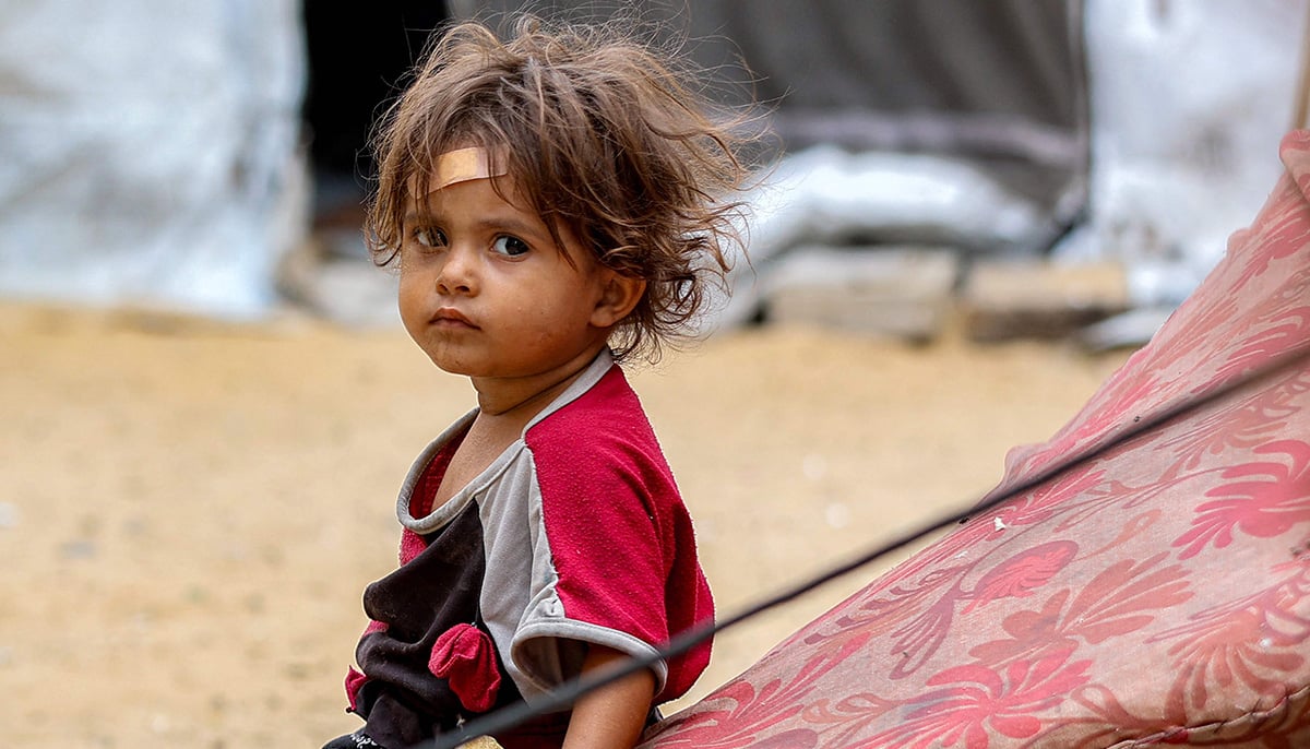 A girl sits outside one of the tents sheltering people displaced by war at the Qatari-built and now-damaged Hamad City residential complex in northwestern Khan Yunis, in the southern Gaza Strip, on October 6, 2025. — AFP