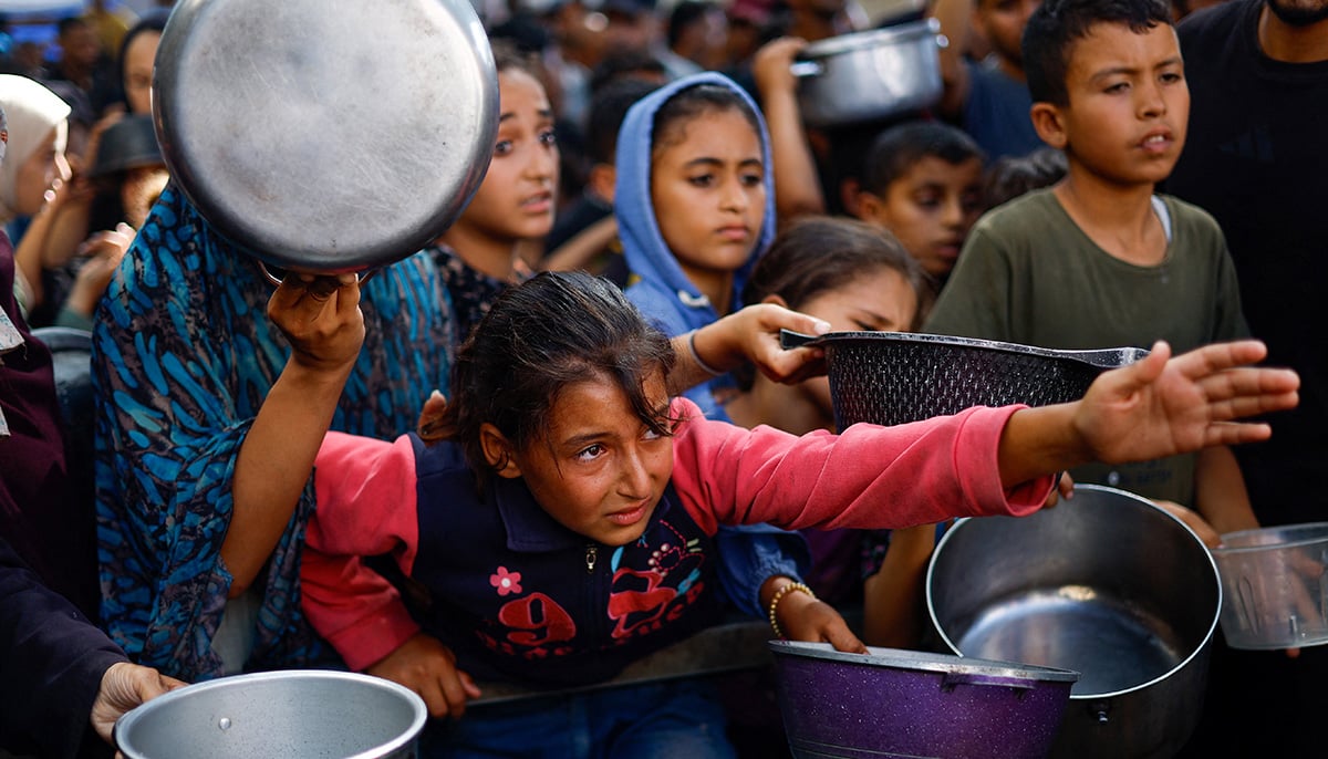 Palestinians gather to receive food from a charity kitchen, in Nuseirat, central Gaza Strip, October 7, 2025. — Reuters