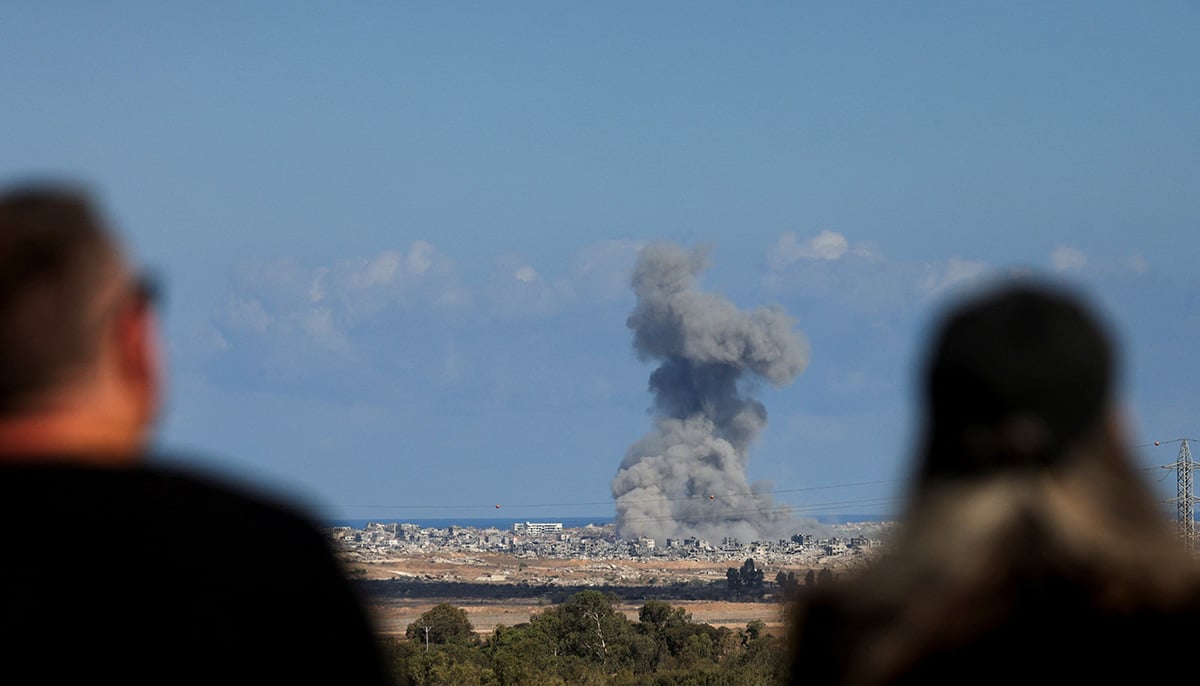 People look at smoke rising from explosions in Gaza, as seen from southern Israel, October 7, 2025. — Reuters