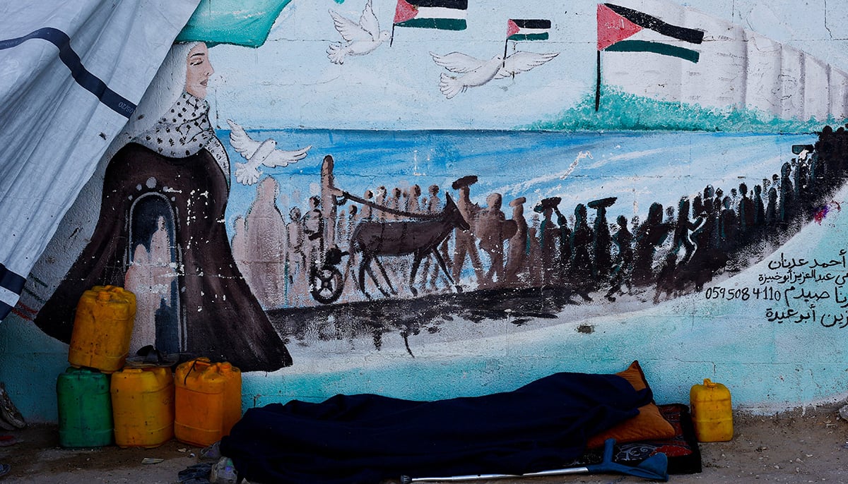 A displaced Palestinian man, who fled his home due to the Israeli military offensive, sleeps in front of his tent, in Nuseirat, central Gaza Strip, October 7, 2025. — Reuters