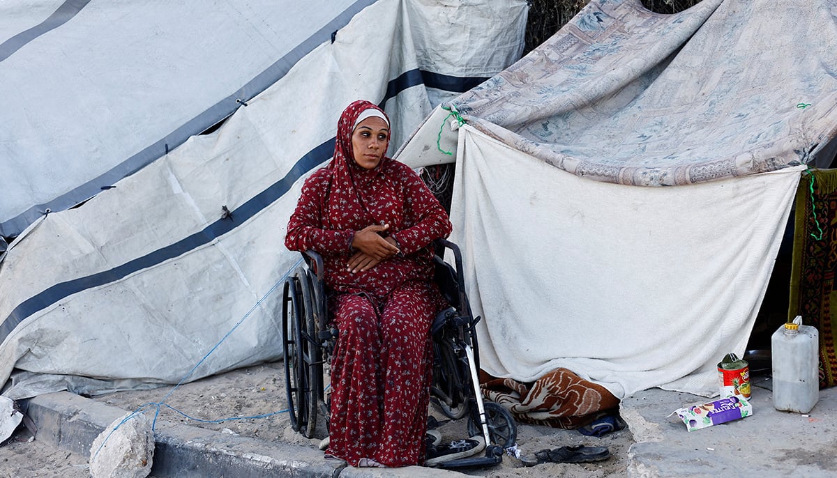 A displaced Palestinian woman, who fled her home due to the Israeli military offensive, sits in front of her tent, in Nuseirat, central Gaza Strip, October 7, 2025. — Reuters