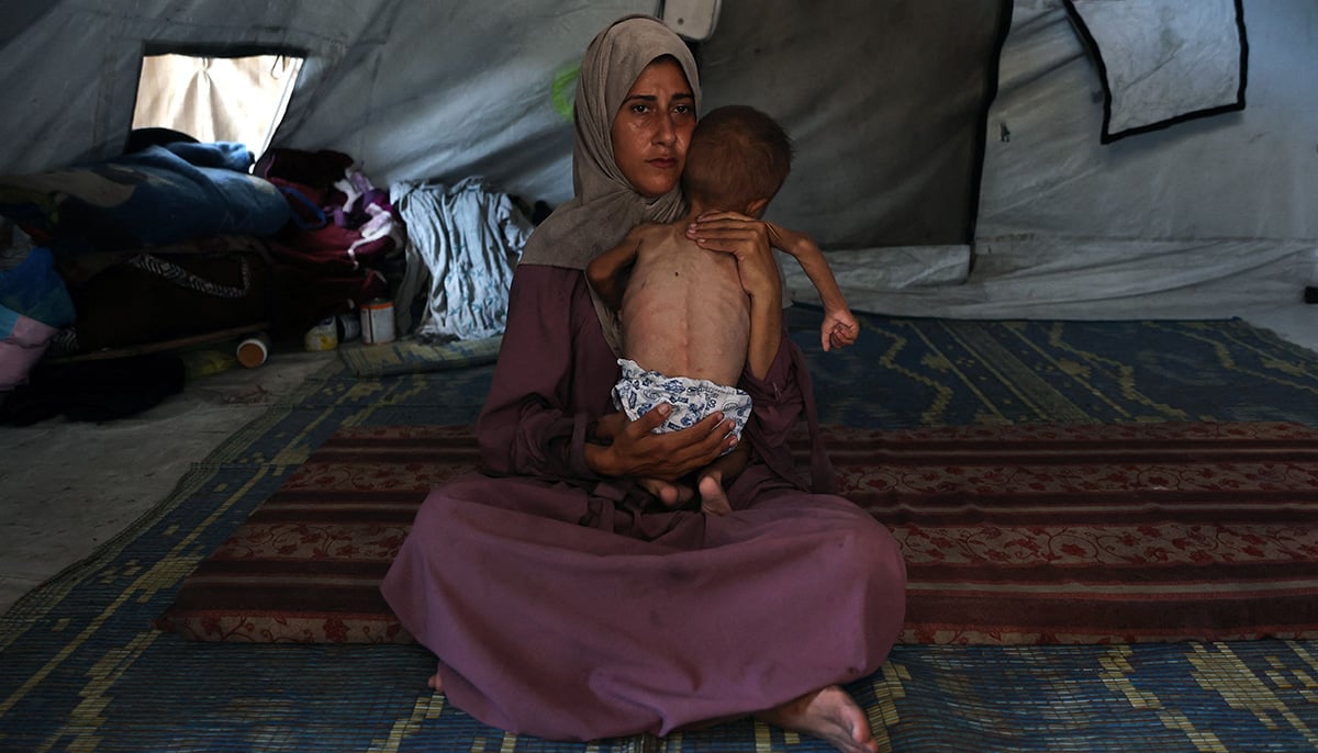 Hidaya, a 31-year-old Palestinian mother, cradles her sick 18-month-old son Mohammed al-Mutawaq, who is also displaying signs of malnutrition, inside their tent at the Al-Shati refugee camp, west of Gaza City, on July 24, 2025. — AFP