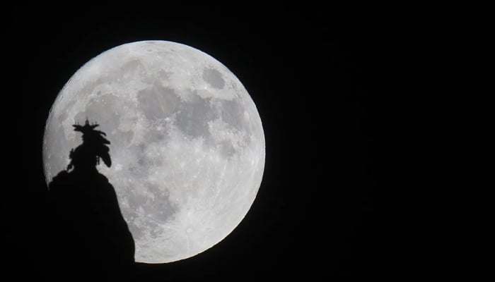 A supermoon rises over the Statue of Freedom on the Capitol dome in Washington, DC. — AFP/File