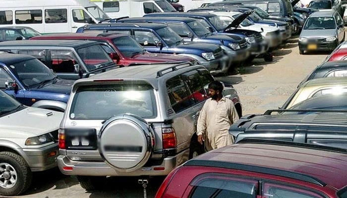An employee of a car showroom walks amidst new cars displayed at an auto dealer centre in Karachi. — AFP/File