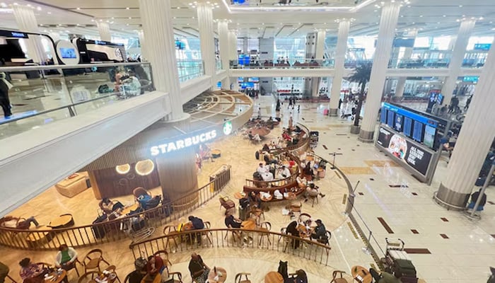 People sit at a coffee shop as they wait for their flight after a rainstorm hits Dubai, causing delays at the Dubai International Airport, in Dubai, United Arab Emirates, April 17, 2024. — Reuters
