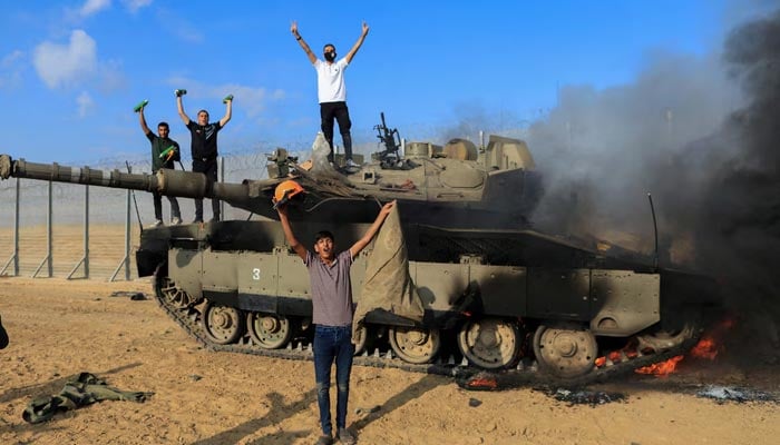 Israeli military vehicle burns after it was hit by Palestinian fighters at the Israeli side of the Israel-Gaza border on October 7, 2023. — Reuters