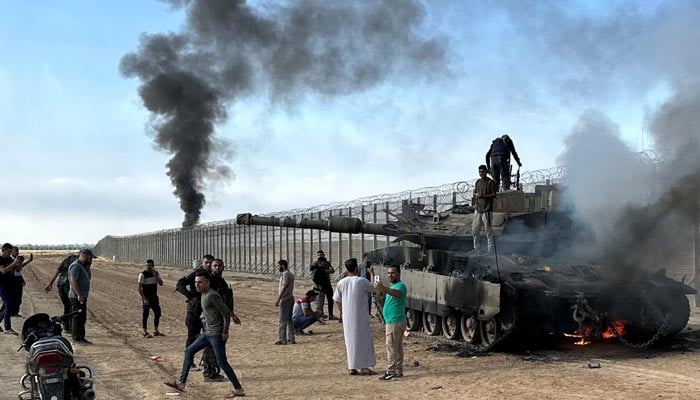 Israeli military vehicle burns after it was hit by Palestinian fighters at the Israeli side of Israel-Gaza border, October 7, 2023. — Reuters
