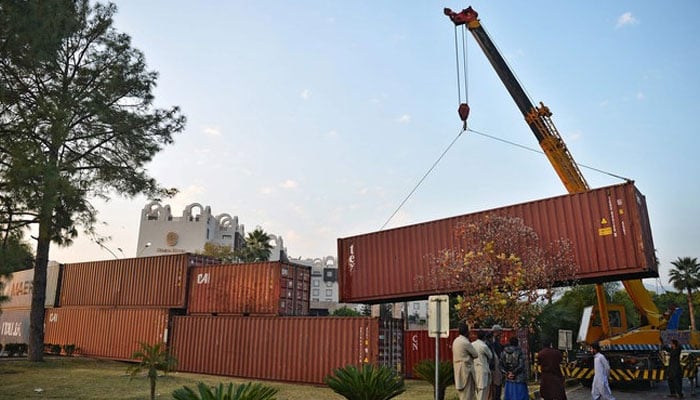 Workers remove a shipping container in front of the French consulate at the end of demonstration by Tehreek-e-Labbaik Pakistan (TLP), in Islamabad on Nov. 17, 2020. — AFP