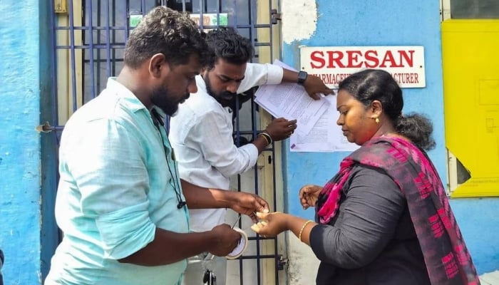 A state health official sticks a notice outside the Sresan Pharmaceutical factory whose Coldrif cough syrup has been linked to the deaths of 17 children in Madhya Pradesh, in Chennai, India, October 7, 2025. — Reuters