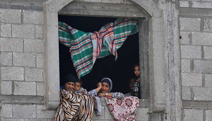 Palestinian women and children look out from a window, after US President Donald Trump announced that Israel and Hamas agreed on the first phase of a Gaza ceasefire, in the central Gaza Strip October 9, 2025. — Reuters