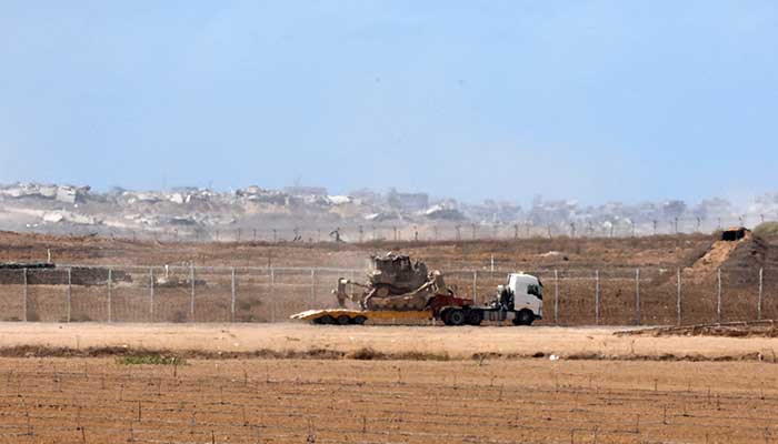 A truck carries an Israeli military tank, after US President Donald Trump announced that Israel and Hamas agreed on the first phase of a Gaza ceasefire, on the Israeli side of the border with Gaza, October 9, 2025. — Reuters