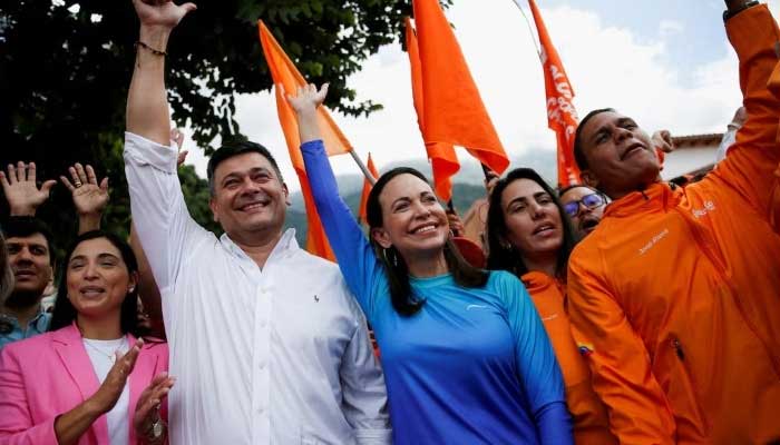 Maria Corina Machado, candidate of the Vente Venezuela party for the opposition primaries and Freddy Superlano, leader of the Voluntad Popular party, raise their arms as they pose for pictures after a press conference, in Caracas, Venezuela, October 13, 2023. — Reuters