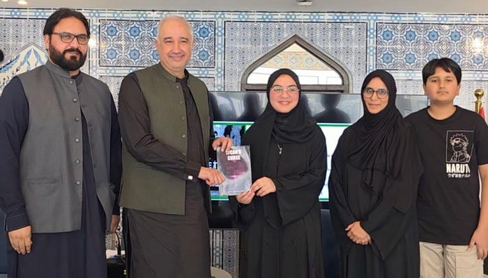 Author Dua Farhan Ahmed presents a copy of her book “The Truth Behind the Evil” to Ambassador Faisal Niaz Tirmizi following the discussion session. — Reporter