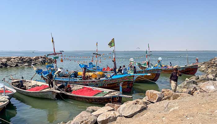Fishers at the dock in Miani Hor. Local people know the lagoon has been made a marine protected area but say they are unaware what that really means for them. — Dialogue Earth