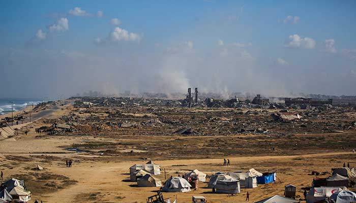 Palestinians walk around tents in Nuseirat in the central Gaza Strip on October 10, 2025. — AFP