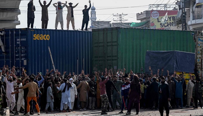 Activists of the Tehreek-e-Labbaik Pakistan shout slogans near their party headquarters in Lahore, as authorities blocked the road with shipping containers, in Lahore on October 9, 2025, ahead of their pro-Palestinian march towards Islamabad. — AFP