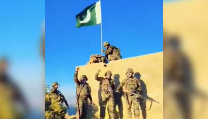 Pakistan Army soldiers hoist national flag at a captured Afghan checkpost at the Pak-Afghan border on October 12, 2025. — Screengrab via Geo News
