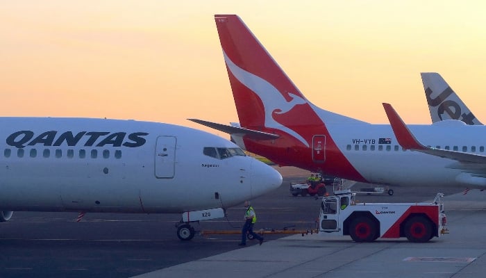 Workers are seen near Qantas Airways, Australias national carrier, Boeing 737-800 aircraft on the tarmac at Adelaide Airport, Australia, August 22, 2018. — Reuters