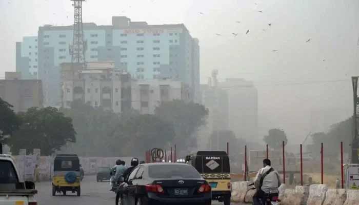 Commuters pictured on MA Jinnah Road near Numaish Chowrangi in Karachi during strong winds. — AFP/File