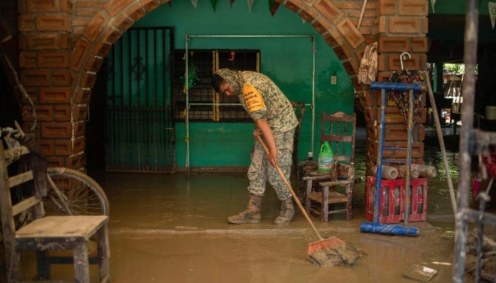 A Mexican Army soldier works to remove the mud from a flooded house due to the heavy rains in the municipality of Alamo, Veracruz, Mexico, on October 12, 2025. — AFP