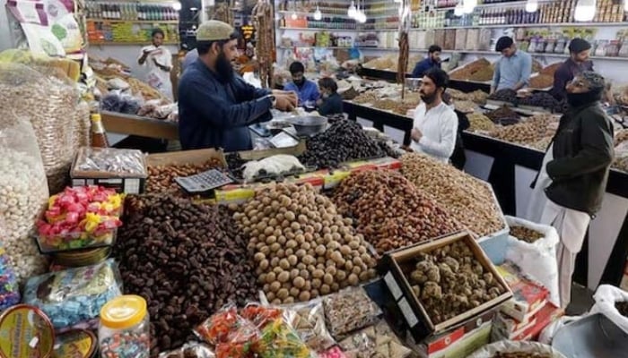 People buy dry fruits at a market in Karachi.— Reuters/File